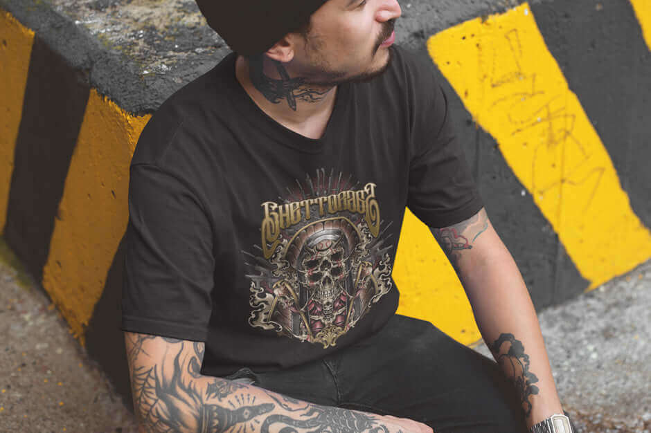 Man wearing Ghetto Gun Nun men's shirt sitting against yellow-black barrier, showcasing streetwear style and rebellion.