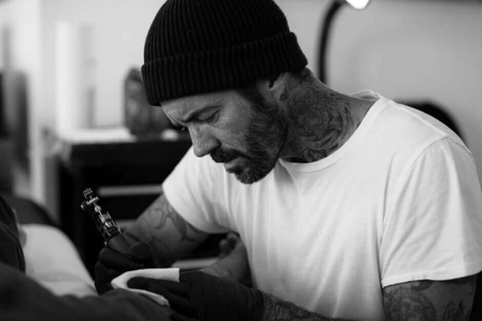 Tattoo artist at work in Lincoln Tattoo Company, Venice Beach, showcasing creativity and dedication to the craft.