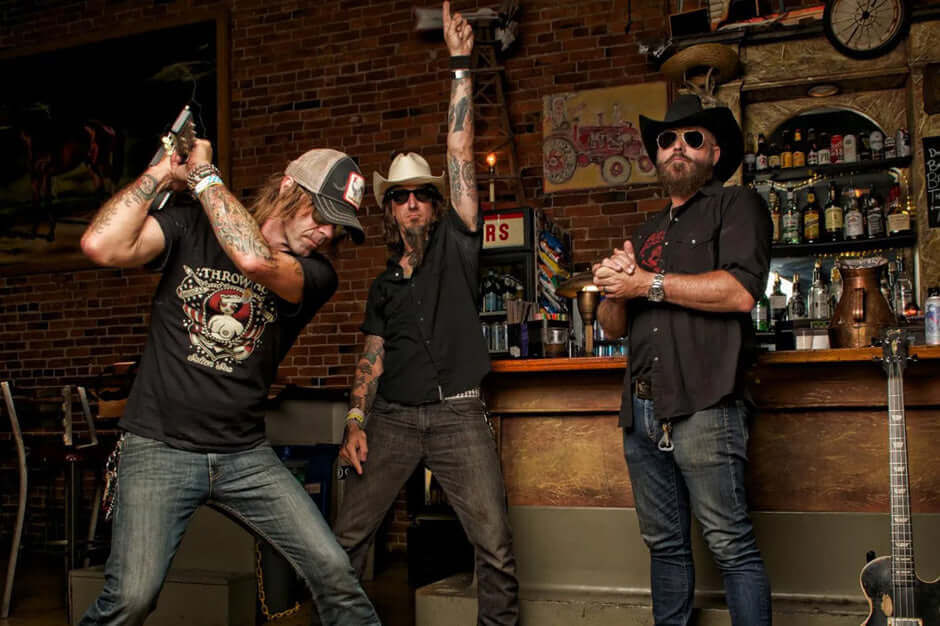 Band members of Supersuckers posing energetically in a rustic bar setting.