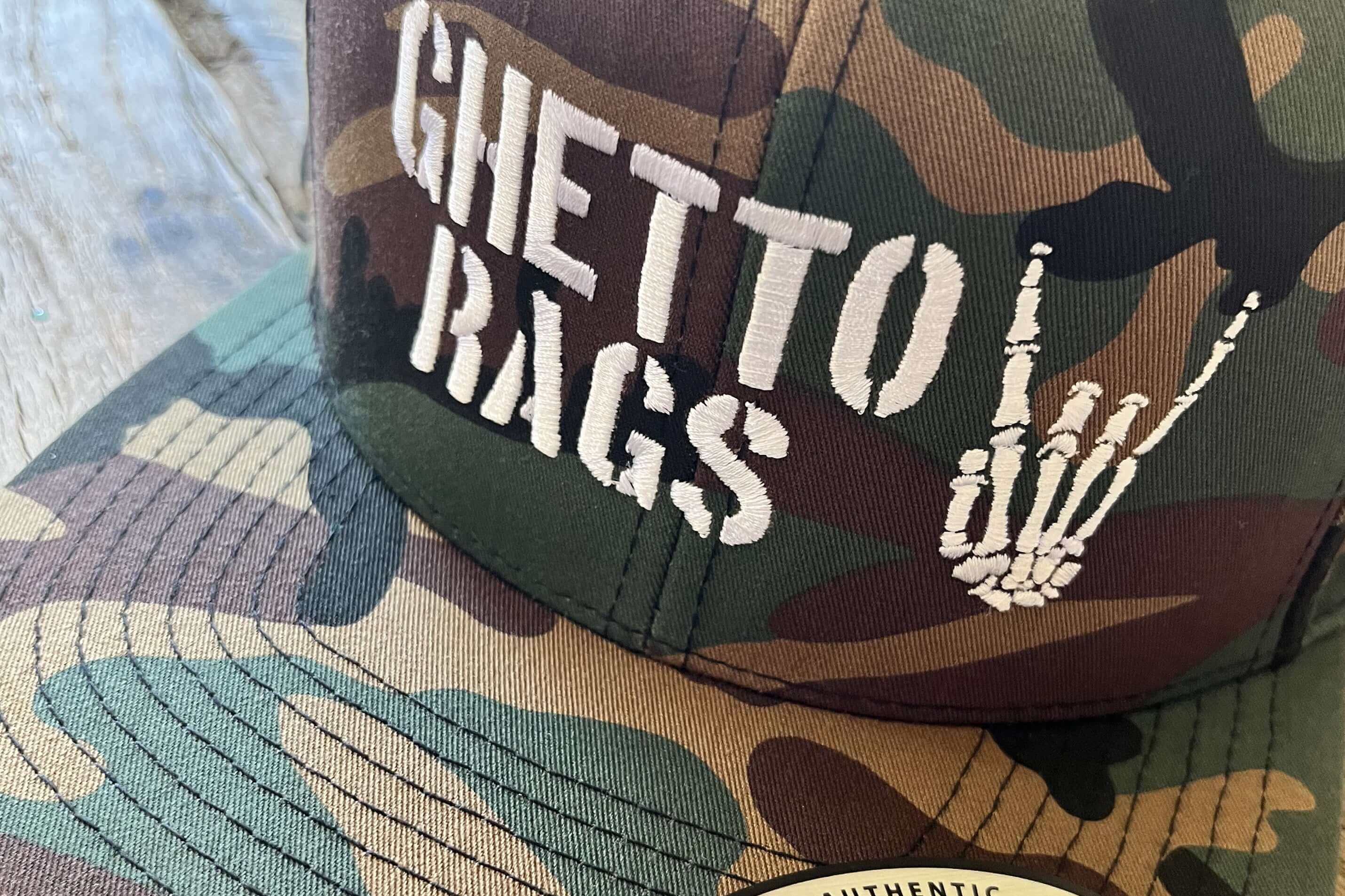 Ghetto Rags camo cap with skeleton hand logo, symbolizing urban skateboarding style and attitude.